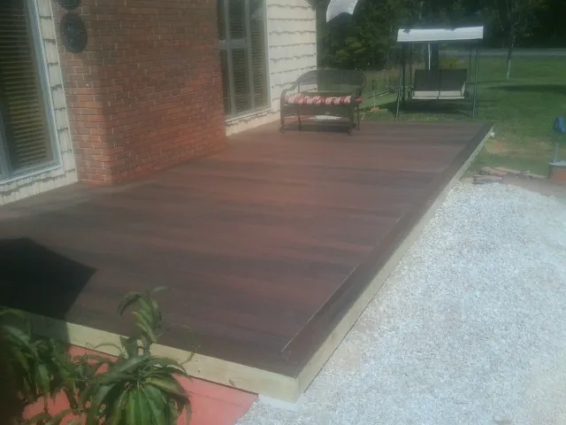 Freshly stained wood deck built against a brick home in Coyote