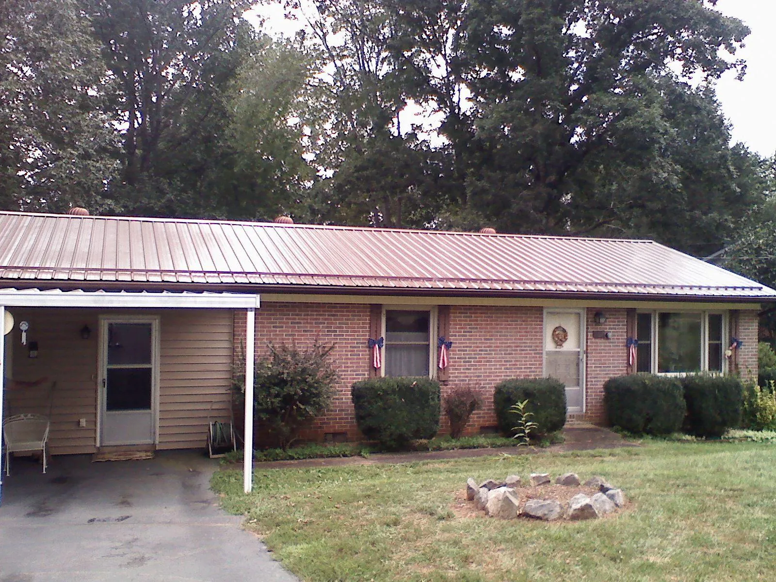 Bronze metal roof and carport on a brick ranch home — Roof Repair work by our crew in Coyote