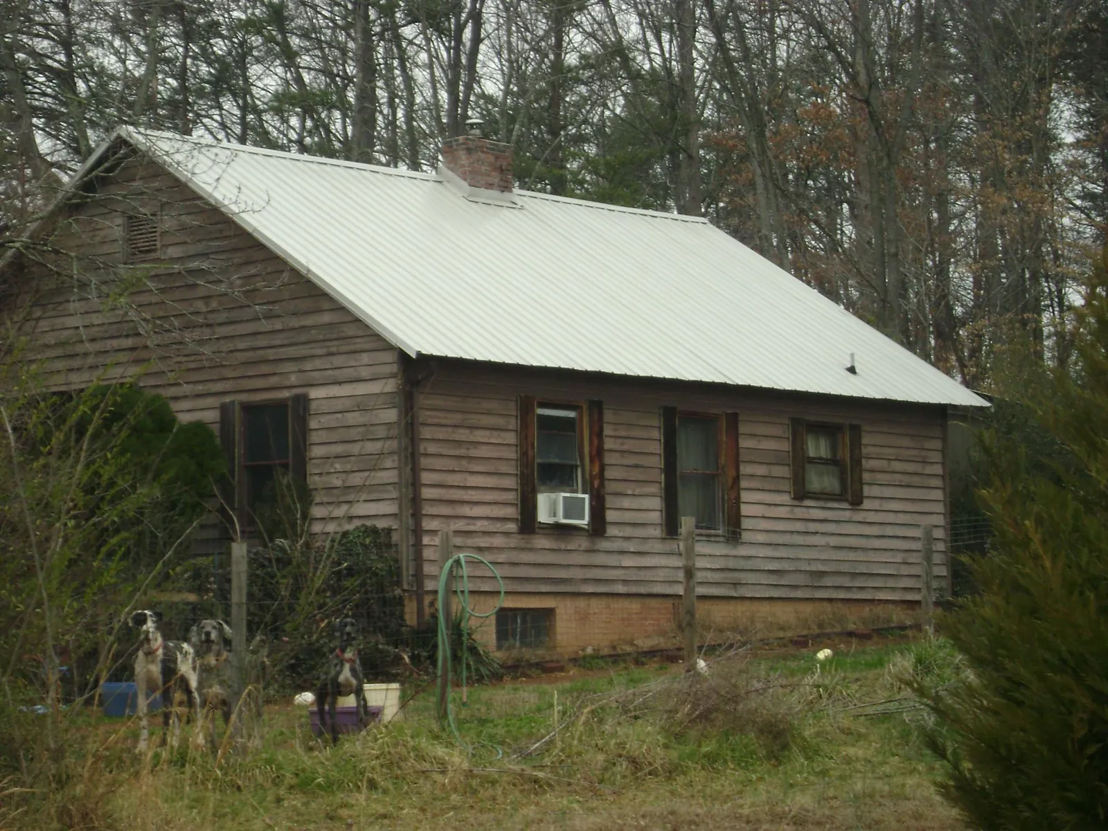 White metal roof on an old wood sided farmhouse, from a Metal Roof Installation job in Coyote